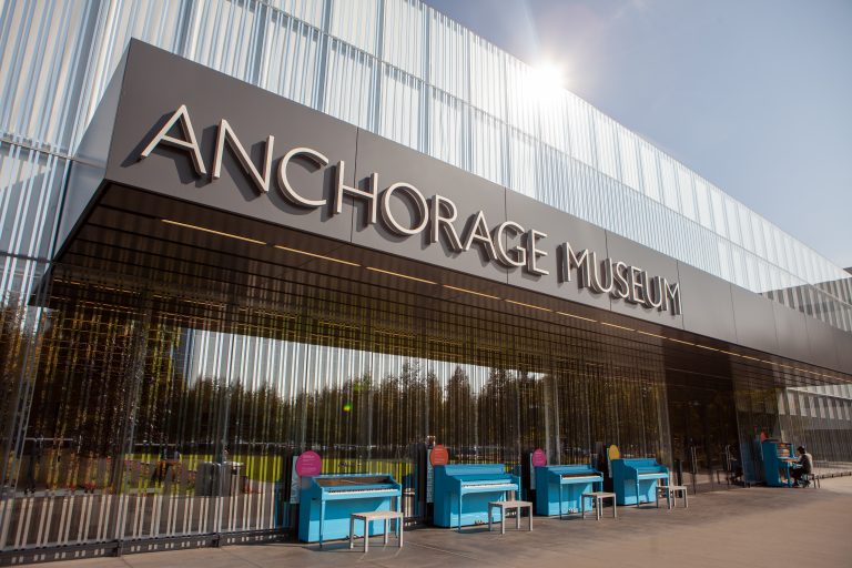 Anchorage Museum building with pianos out front
