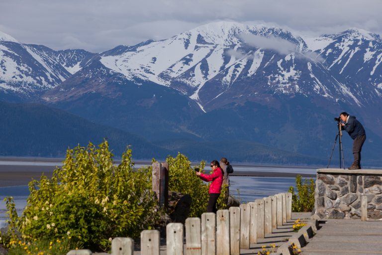 photographers take pictures by the side of the Seward Highway with alaskan mountains in the background