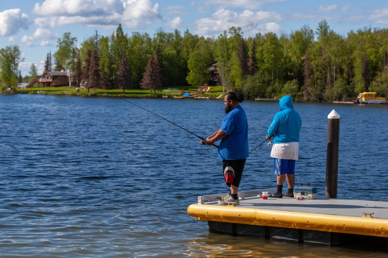 Fishermen cast from a dock on a sunny day at Big Lake