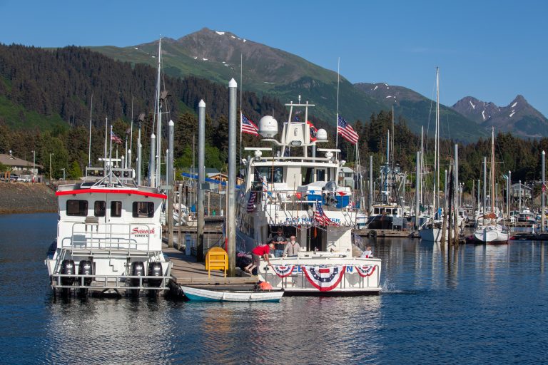 Boat with red, white and blue decorations on a sunny day in a Seldovia Harbor