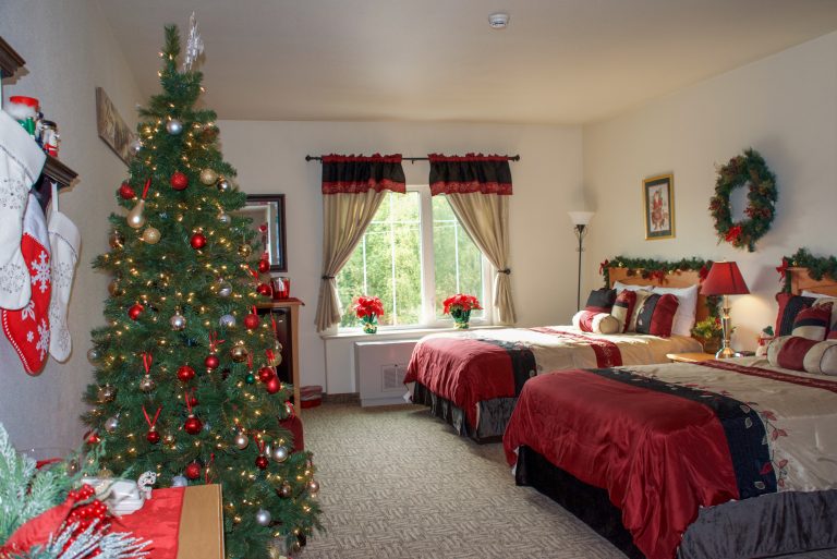 hotel room decorated with christmas tree and red sheets
