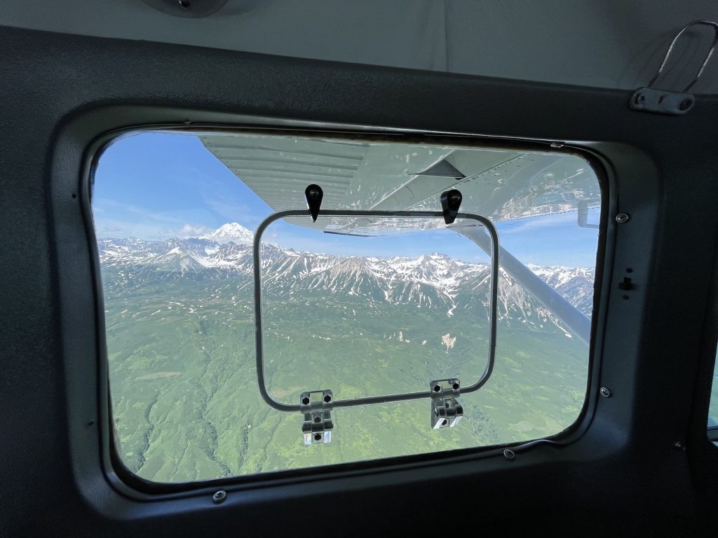 Square cutout capable of cracking open underneath wing in airplane window
