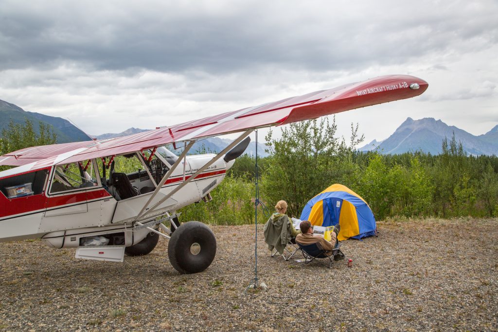 plane, tent, and people on remote airstrip