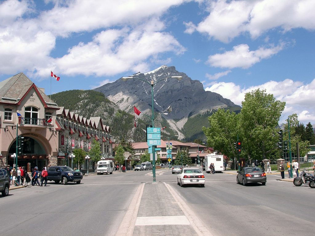 A street running through Banff and a tall mountain in the background