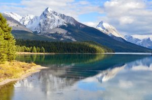Calm lake, surface reflects snow-capped mountains